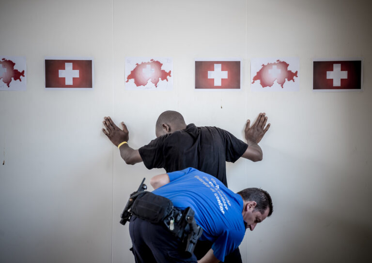 Ein Angehoeriger des Grenzwachtkorps durchsucht am Zoll des Bahnhofs Chiasso einen Migranten, aufgenommen am Samstag, 20. Juni 2015. In den vergangenen Tagen sind ueberdurchschnittlich viele Asylsuchende in die Schweiz gelangt. Im Empfangs- und Verfahrenszentrum Chiasso kam es deswegen zu Engpaessen. (KEYSTONE/Ti-Press/Pablo Gianinazzi)