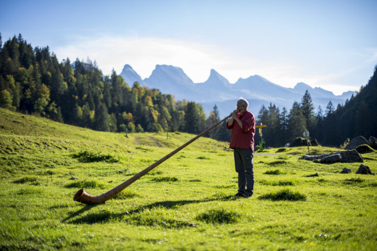 Stephan Ruegg, ein Tourist aus Winterthur, spielt sein Alphorn in freier Natur auf der Alp Laui, im Hintergrund die Bergkette der Churfirsten, am Freitag, 5. Oktober 2018, in Unterwasser. (KEYSTONE/Gian Ehrenzeller)..Stephan Ruegg, a tourist from Winterthur, plays his Alphorn in the outdoors on Alp Laui, in the background the Churfirsten mountain range, on Friday, 5 October 2018, in Unterwasser, Switzerland. (KEYSTONE/Gian Ehrenzeller)