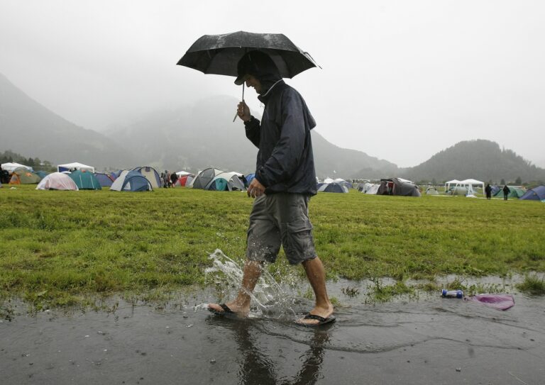 Ein Festivalbesucher des Greenfield Openairs in Interlaken schreitet am Freitag, 15. Juni 2007, bei stroemendem Regen durch eine Pfuetze. Das Festival beginnt heute Freitag und dauert bis am Sonntag. (KEYSTONE/ Peter Schneider)

A visitor of the Greenfield Open-Air music festival in Interlaken, Switzerland, steps through a puddle under poring rain on Friday, June 15, 2007. The festival lasts till Sunday and features acts like, amongst others, Marilyn Manson, The Killers, The Smashing Pumkins, Slayer, Queens of the Stone Age, Manic Street Preachers and Sonic Youth. (KEYSTONE/Peter Schneider)