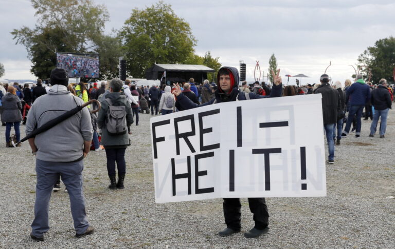 epa08719077 A protester holds a banner reading 'Freedom' during a demonstration by 'Querdenker' movement held against coronavirus restrictions, at Lake Constance in Konstanz, Germany, 04 October 2020. Various demonstrations and rallies against and in favor of coronavirus restrictions take place on 03 and 04 October in Konstanz. EPA/RONALD WITTEK