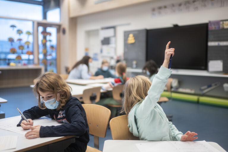 Eine Schuelerin traegt im Lehrunterricht eine Hygienemaske, um sich und andere gegen eine Uebertragung des Coronavirus zu schuetzen, in einem Schulzimmer der Schule Pfingstweid in Zuerich, aufgenommen am Dienstag, 11. Januar 2022. Um nach den Weihnachtsferien den Schulbetrieb moeglichst sicher starten zu koennen, wurde die Maskentragpflicht in Zuerich und anderen Kantonen ab dem 3. Januar 2022 auch auf Schuelerinnen und Schueler der 1. bis 3. Primarschulklassen ausgeweitet. (KEYSTONE/Ennio Leanza)