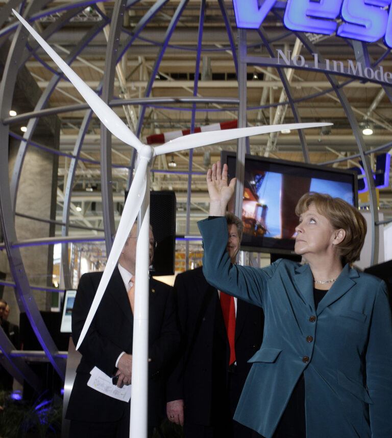 Bundeskanzlerin Angela Merkel deutet am 21.April 2008 in Hannoveram Stand der Windenergie Firma Vestas auf der Hannover Messe auf eine Windrad. Der Bundesverband Windenergie hat eine Anpassung der Verguetung fuer Windstrom an gestiegenen Rohstoffpreise gefordert. Ohne eine Anhebung koenne Deutschland seine Position als Exportweltmeister bei Windkraftanlagen nicht dauerhaft behaupten und seine Klimaschutzziele nicht erreichen. (AP Photo/Fabian Bimmer) --- German Chancellor Angela Merkel is pictured at the booth of German windpower company Vestas at the Hannover fair in Hanover, Germany, on Monday, April 21, 2008. (AP Photo/Fabian Bimmer)