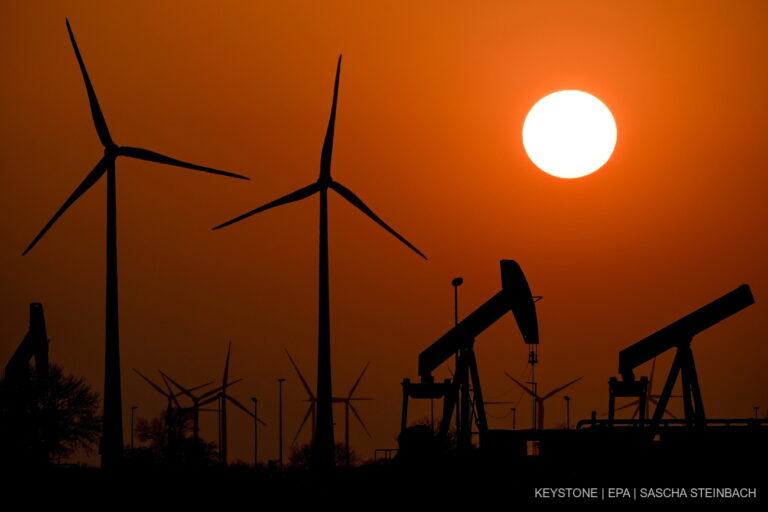 epa09842945 Pump jacks of the German Wintershall Dea company convey crude oil as the sun sets behind an oil field near wind energy generators close to the German-Durch border in Emlichheim, Germany, 22 March 2022. The Russian invasion of Ukraine has led many governments besides Germany aiming at becoming less dependent on Russian oil and gas imports. EPA/SASCHA STEINBACH