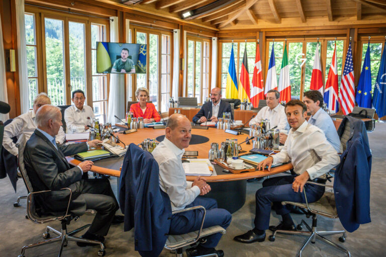 27.06.2022, Bayern, Elmau: Die Gipfelteilnehmer Bundeskanzler Olaf Scholz (Mitte vorn, SPD), US-Präsident Joe Biden (l-r, im Uhrzeigersinn), Boris Johnson, Premierminister von Großbritannien, Fumio Kishida, Premierminister von Japan, Ursula von der Leyen, EU- Kommissionspräsidentin, Charles Michel, EU- Ratspräsident, Mario Draghi, Premierminister von Italien, Justin Trudeau, Premierminister von Kanada und Emmanuel Macron, Präsident von Frankreich, sitzen bei der Arbeitssitzung, während der ukrainische Präsident Wolodymyr Selenskyj per Videokonferenz zugeschaltet ist. Beim G7-Gipfel wirtschaftsstarker Demokratien geht es um die weitere, auch langfristige Unterstützung seines Landes. Außerdem wird es in Beratungen mit den fünf Gastländern Indien, Indonesien, Südafrika, Senegal und Argentinien um die Themen Klimaschutz und die weltweite Ernährungskrise infolge des Ukraine-Kriegs gehen. Foto: Michael Kappeler/dpa +++ dpa-Bildfunk +++ (KEYSTONE/DPA/Michael Kappeler)