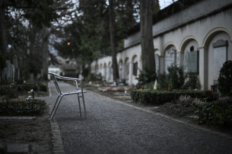 Ein Stuhl steht vor einem Grabstein, aufgenommen am Samstag, 28. Januar 2023, auf dem Friedhof Daleu in Chur. (KEYSTONE/Gian Ehrenzeller)