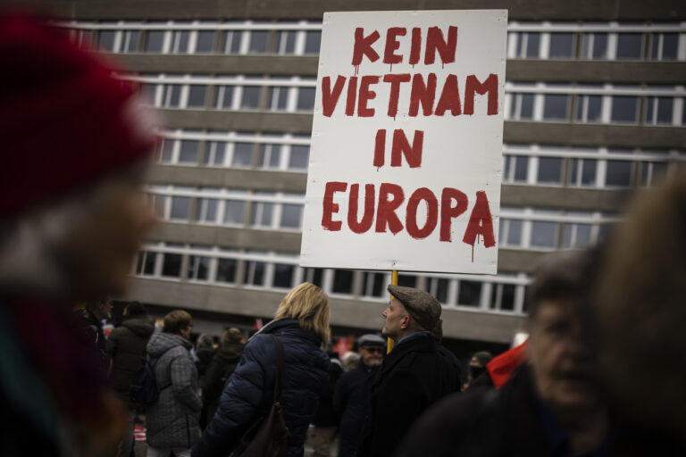 A protestor holds a placard reading 