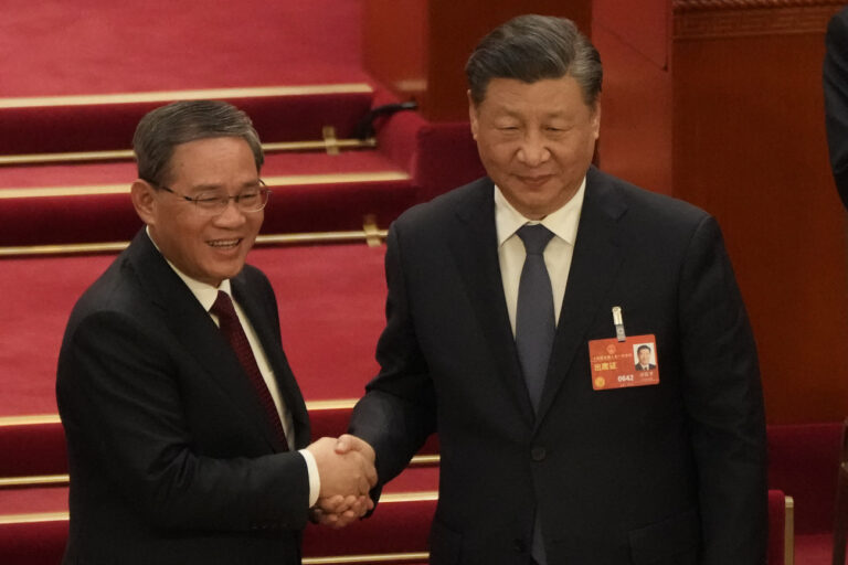 Newly elected Premier Li Qiang at left shakes hands with Chinese President Xi Jinping during a session of China's National People's Congress (NPC) at the Great Hall of the People in Beijing, Saturday, March 11, 2023. (AP Photo/Mark Schiefelbein)