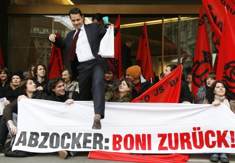 Gegen 30 Demonstrantinnen und Demonstranten, Mitglieder der Jusos, fordern eine Rueckzahlung der Boni von Bankenchefs am Donnerstag, 23. Oktober 2008, vor dem Hauptsitz der UBS in Zuerich. (KEYSTONE/Steffen Schmidt)

An UBS banker walks over a transparent while around 30 members of the Young Socialist party demonstrate in front of the headquarters of Switzerland's biggest bank UBS in Zurich, Switzerland, Thursday, October 23, 2008 demanding the payback of banker's bonuses. (KEYSTONE/Steffen Schmidt)