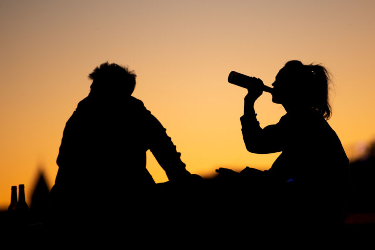 ARCHIV - 21.09.2019, Nordrhein-Westfalen, Köln: Ein Mann und eine Frau sitzen in der Abenddämmerung und trinken aus Flaschen. (zu dpa: «Mithalten auch beim Alkohol: Mehr junge Frauen mit riskantem Konsum») Foto: Marius Becker/dpa +++ dpa-Bildfunk +++ (KEYSTONE/DPA/Marius Becker)