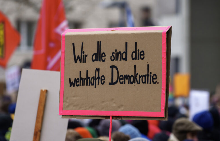 ARCHIV - 21.01.2024, Hessen, Offenbach: Ein Plakat ·Wir alle sind die wehrhafte Demokratie· wird auf einer Kundgebung gegen Rechtsextremismus am Rathaus gezeigt. Am Freitag sind in Kiel und Norderstedt erneut Demonstrationen gegen Rechtsextremismus geplant. (zu dpa: «Einschüchterungsversuche bei Demos gegen rechts - Gefahr im Wahlkampf?») Foto: Andreas Arnold/dpa +++ dpa-Bildfunk +++ (KEYSTONE/DPA/Andreas Arnold)