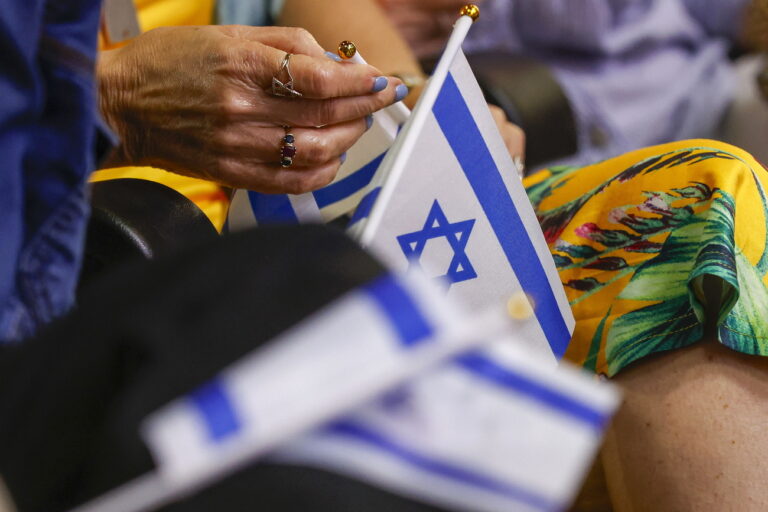 epa11380517 A person holds an Israeli flag during a People's Resolution hearing to demand that the city take a stance on the conflict in Gaza, at Austin City Hall in Austin, Texas, USA, 30 May 2024. More than 36,000 Palestinians and over 1,400 Israelis have been killed, according to the Palestinian Health Ministry and the Israel Defense Forces (IDF), since Hamas militants launched an attack against Israel from the Gaza Strip on 07 October 2023, and the Israeli operations in Gaza and the West Bank which followed it. EPA/Adam Davis