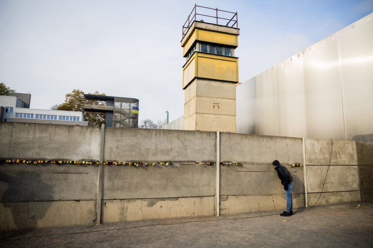 dpatopbilder - 09.11.2024, Berlin: Blumen stecken nach einer zentralen Gedenkveranstaltung anlässlich von 35 Jahre friedliche Revolution und Mauerfall in der Gedenkstätte Berliner Mauer in der Hinterlandmauer. Foto: Christoph Soeder/dpa +++ dpa-Bildfunk +++ (KEYSTONE/DPA/Christoph Soeder)