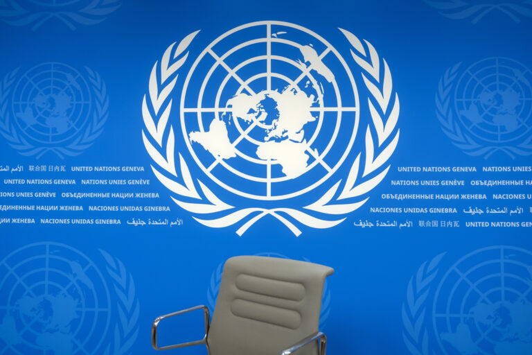 The U.N. logo on backdrop of the UN press room is pictured at the European headquarters of the United Nations, in Geneva, Switzerland, Monday, December 9, 2024. (KEYSTONE/Salvatore Di Nolfi)