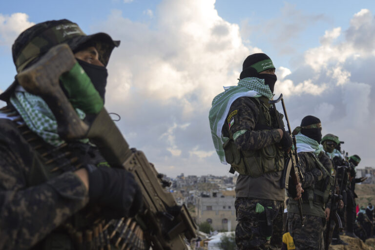 Hamas fighters take up a position ahead of handing over four bodies to the Red Cross in Khan Younis, southern Gaza Strip, Thursday, Feb. 20, 2025. Israel has identified three of the bodies as hostages and said the other was of an unknown person. (AP Photo/Abdel Kareem Hana)