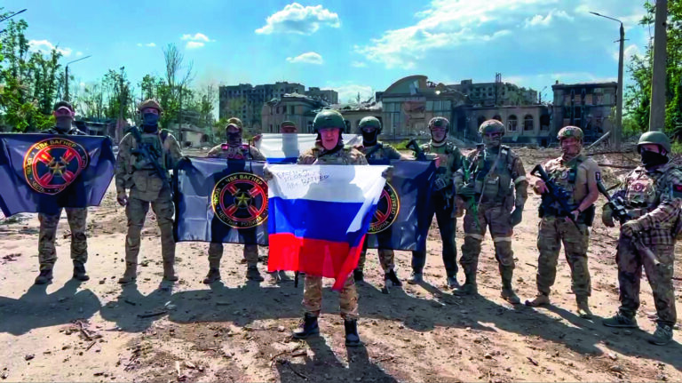 In this handout photo taken from video and released by Prigozhin Press Service Saturday, May 20, 2023, Yevgeny Prigozhin, the head of the Wagner Group military company speaks holding a Russian national flag in front of his soldiers in Bakhmut, Ukraine. Prigozhin claims his forces have taken control of the city of Bakhmut after the longest and most grinding battle of the Russia-Ukraine war, but Ukrainian defense officials have denied it. In a video posted on Telegram, Prigozhin said the city came under complete Russian control at about midday Saturday. (Prigozhin Press Service via AP)