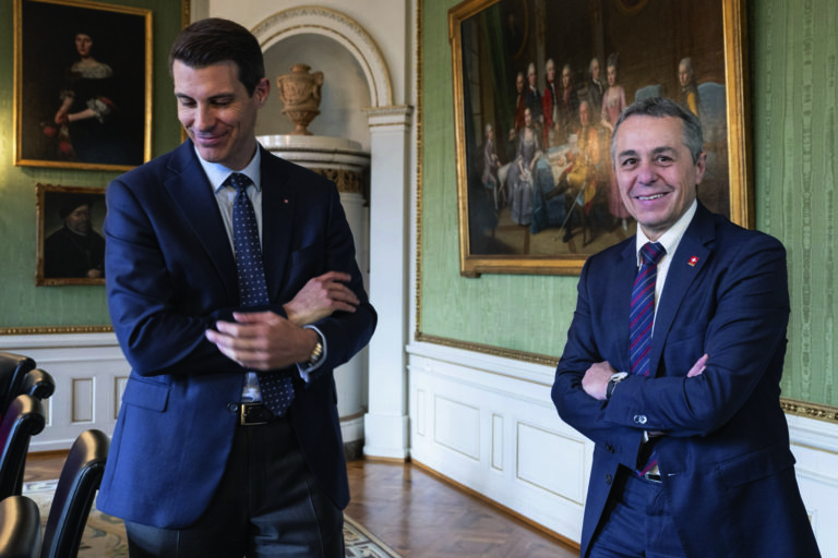 Bundesrat Ignazio Cassis, rechts, und Staenderat Thierry Burkart, FDP-AG unterhalten sich neben Kameramann Bjoern Kurt an den von Wattenwyl Gespraechen, am Freitag, 17. November 2023, in Bern. (KEYSTONE/Peter Schneider)